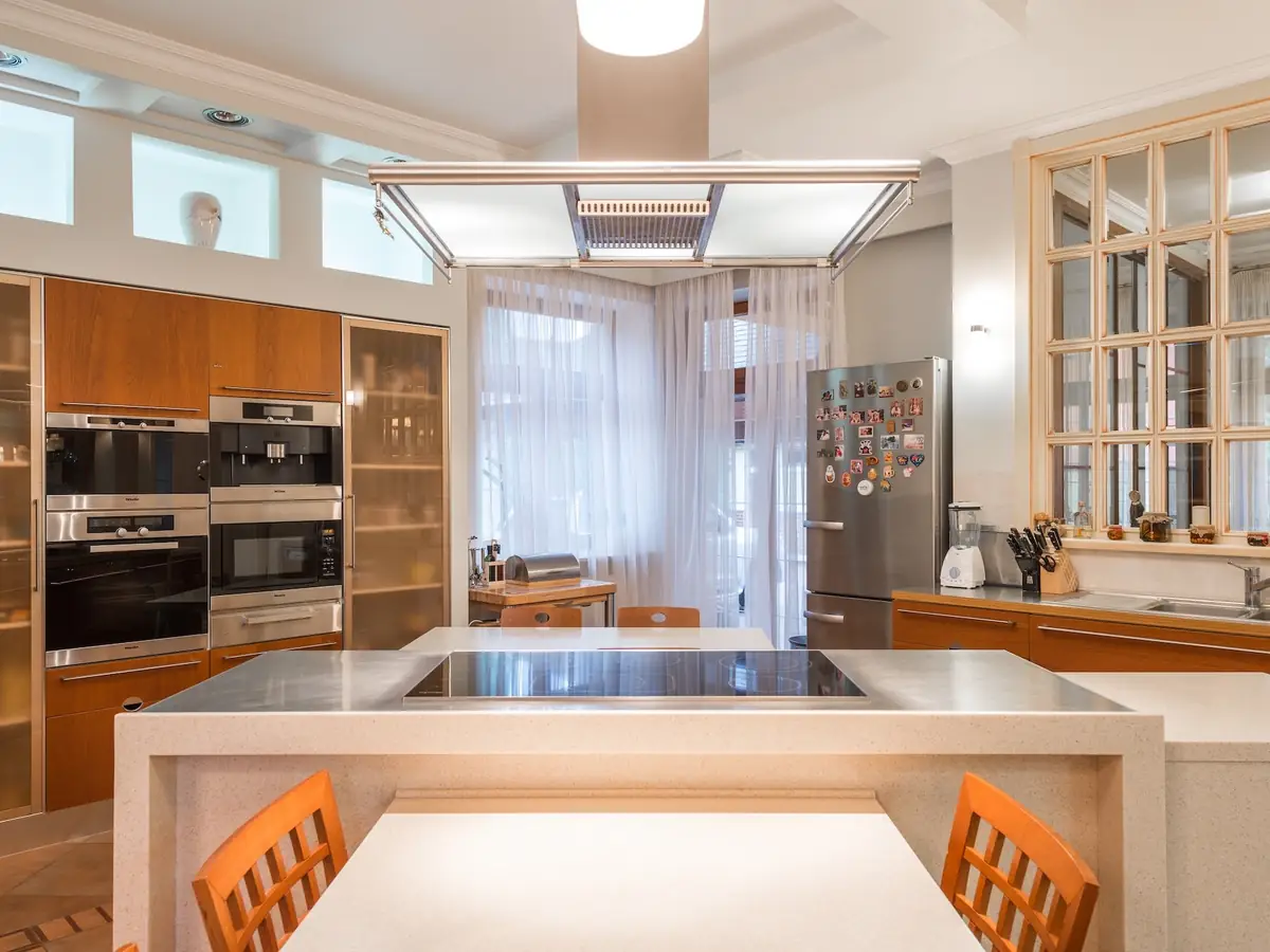 Bright kitchen with built-in wall ovens, a cooktop, and a refrigerator